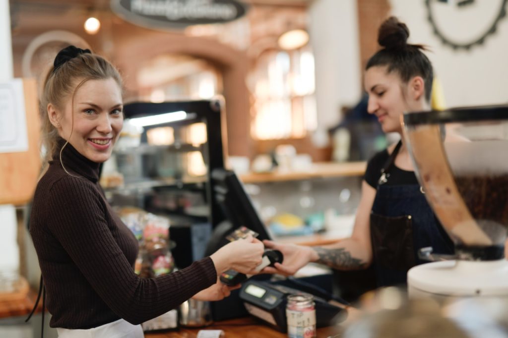 woman-in-black-long-sleeve-shirt-paying-at-a-cashier